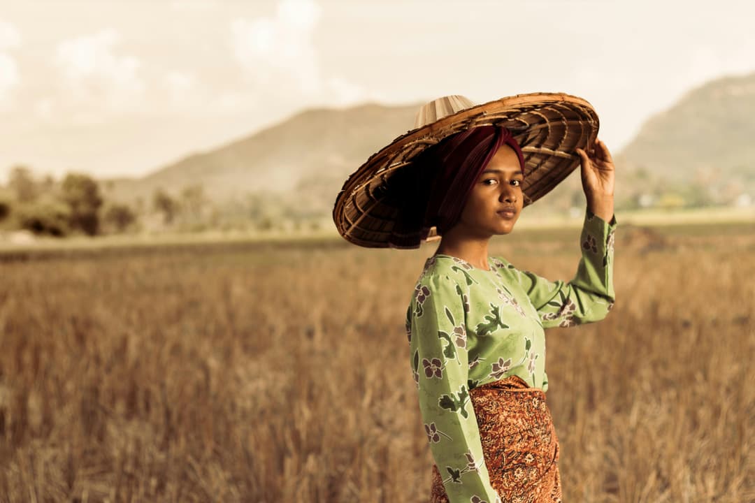 model mengenakan batik dengan latar belakang alam